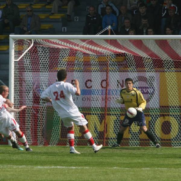 A 11-a-side football game is performing on the field.
