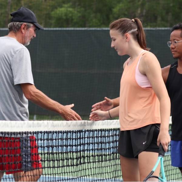 Tennis players are shaking hands before the game.