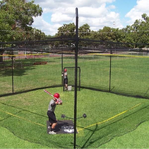 A baseball cage net installed in a home yard.