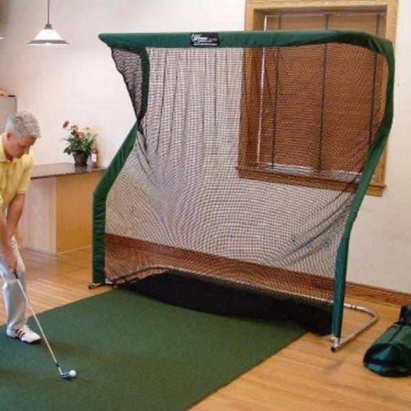 A man is playing the golf indoors.