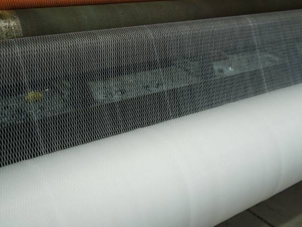 The machine is producing white rope netting product.