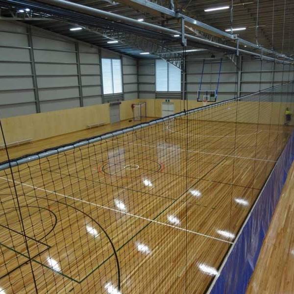 Court divider net is installed around the indoor basketball court.