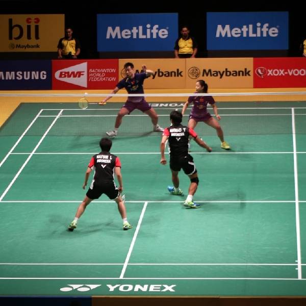 Players are undergoing a badminton match in the stadium.
