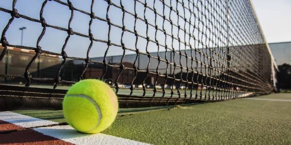 Le tennis tombe à côté du filet de tennis.