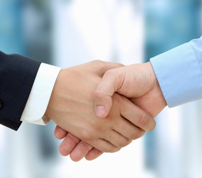 2 businessmen are shaking hands.