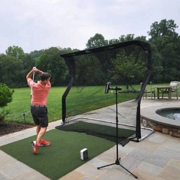 A man is playing the golf in the yard.